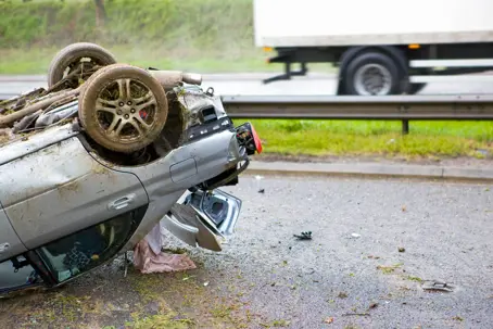 An overturned car next to a highway during a traffic accident in Texas